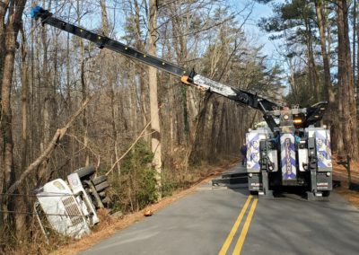 Sullivan's Towing & Recovery using a crane to recover an overturned truck