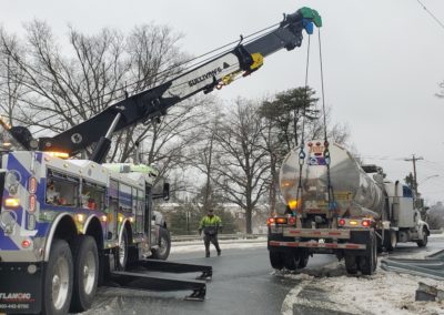 Sullivan's Towing & Recovery overturning an oil truck on a snowy road