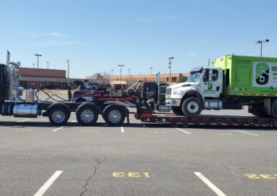 Sullivan's Towing & Recovery, LLC towing a garbage truck