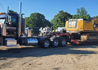 Sullivan's Towing & Recovery truck towing a CAT construction vehicle